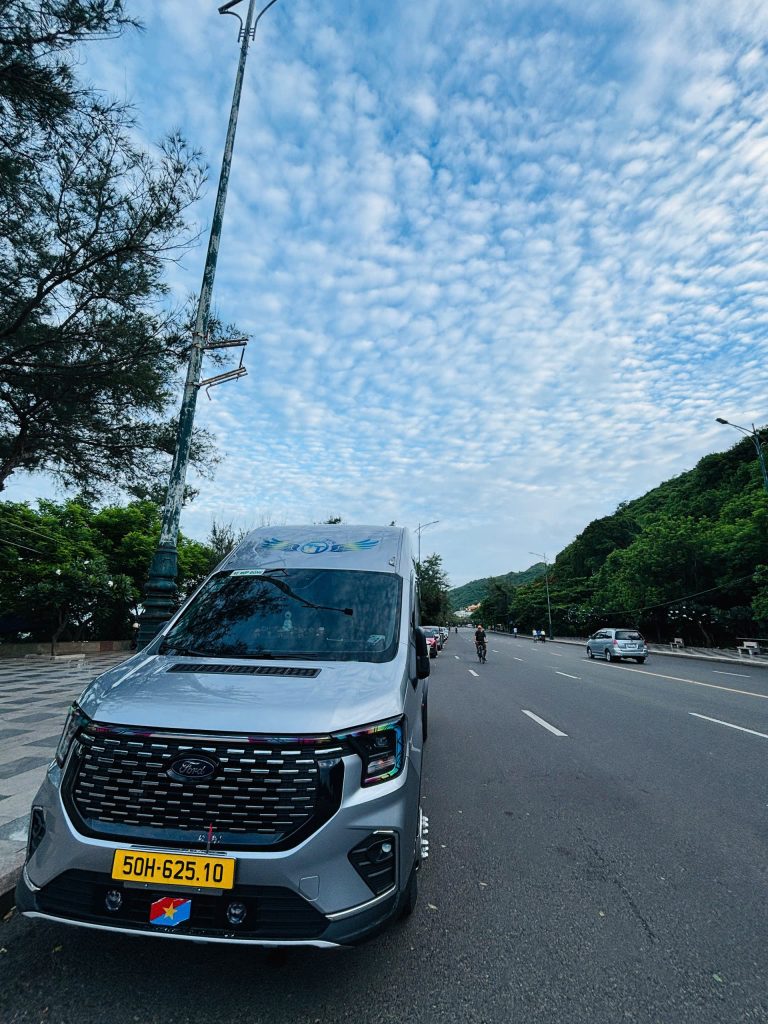 Xe 16 chỗ màu trắng đang di chuyển trên đường
